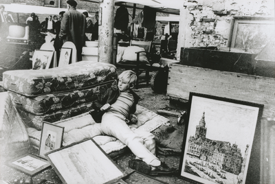 875412 Afbeelding van een jongetje dat op een matras ligt bij een uitstalling op een rommelmarkt in Wijk C te Utrecht, ...